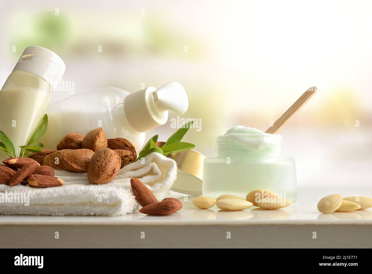 Bagno e prodotti cosmetici con estratto di mandorle e articoli da toeletta su tavola bianca in bagno. Vista frontale. Composizione orizzontale. Foto Stock