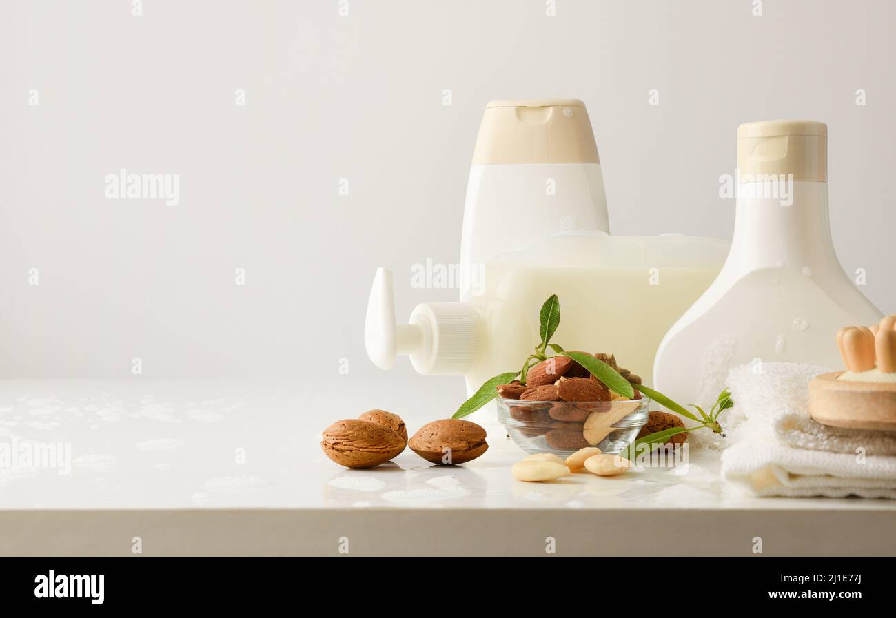 Prodotti da bagno con estratto di mandorle e prodotti da bagno su tavola bianca in bagno sfondo isolato. Vista frontale. Composizione orizzontale. Foto Stock