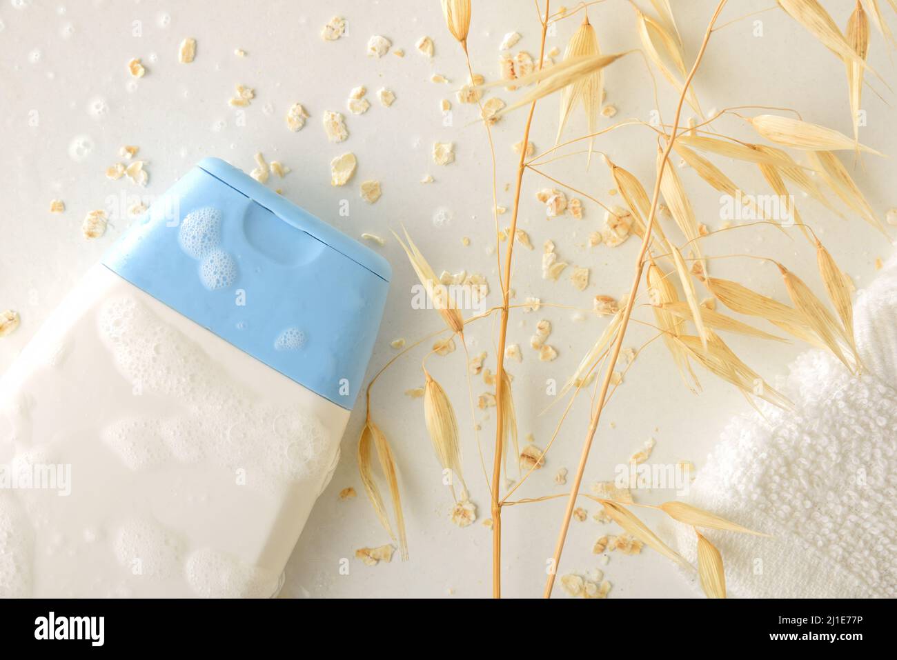 Particolare di gel da bagno o shampoo con estratto di avena su tavola bianca con cannucce. Vista dall'alto. Composizione orizzontale. Foto Stock