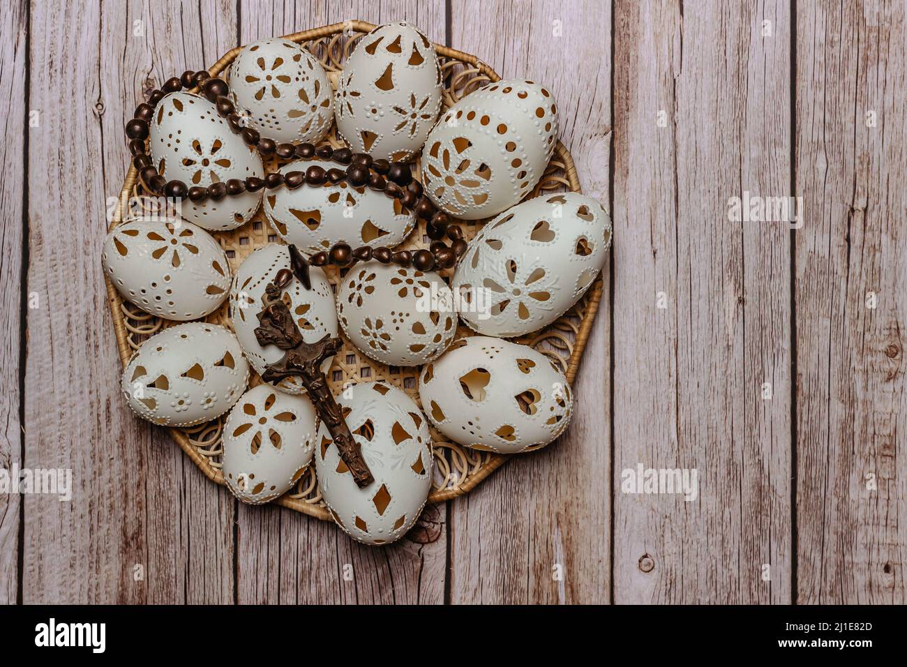 Happy Easter.White mano fatto uova di Pasqua con crocifisso in legno basket.Spring decorazione sfondo. Tradizione festosa per il simbolo cristiano.religioso Foto Stock