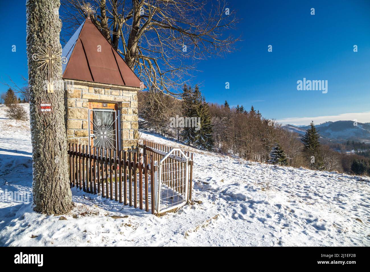 Vista del paesaggio invernale con una cappella sopra il villaggio Dlhe Pole nel nord della Slovacchia, Europa. Foto Stock