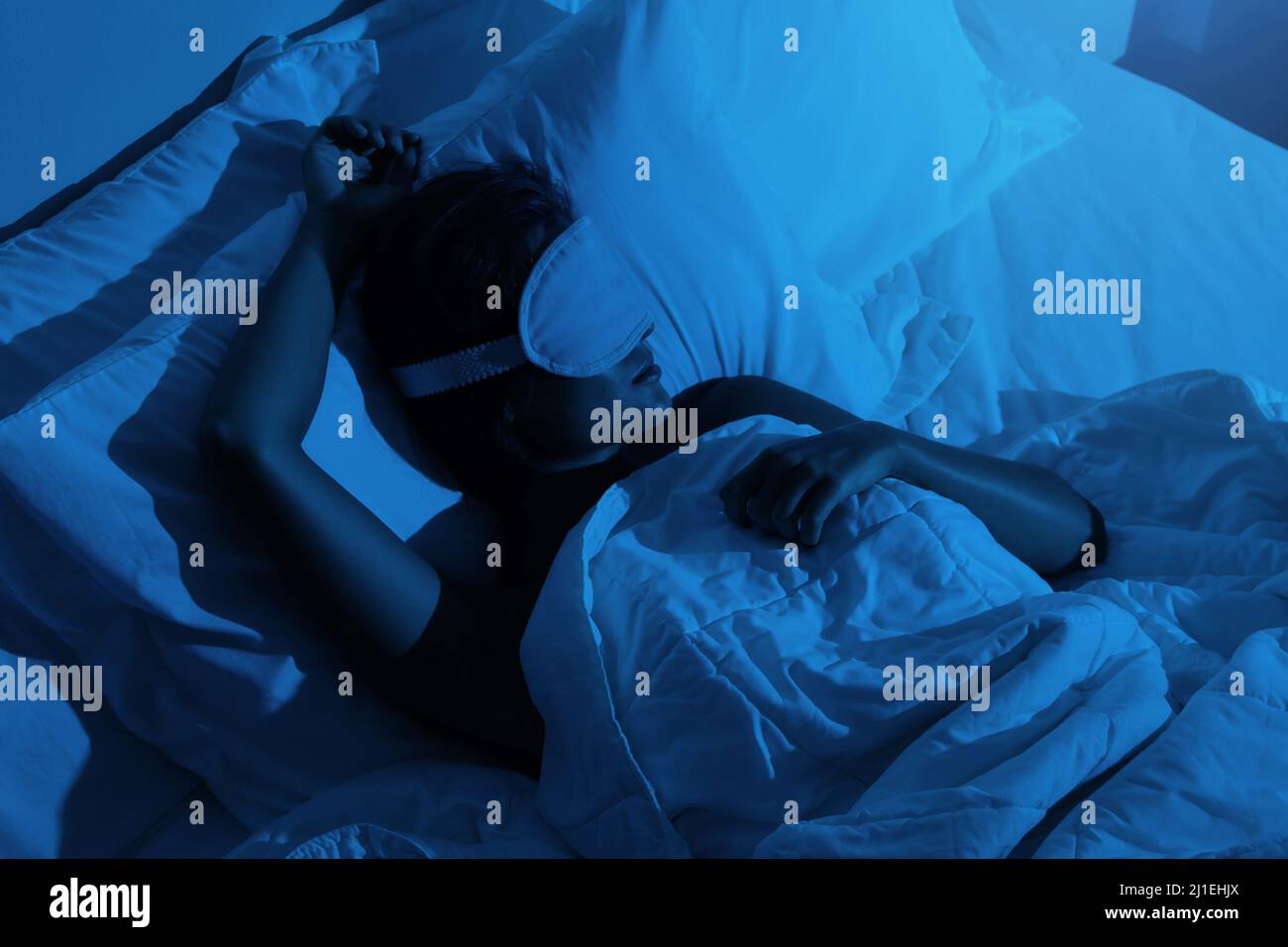 Donna che dorme con una maschera di sonno sugli occhi Foto Stock