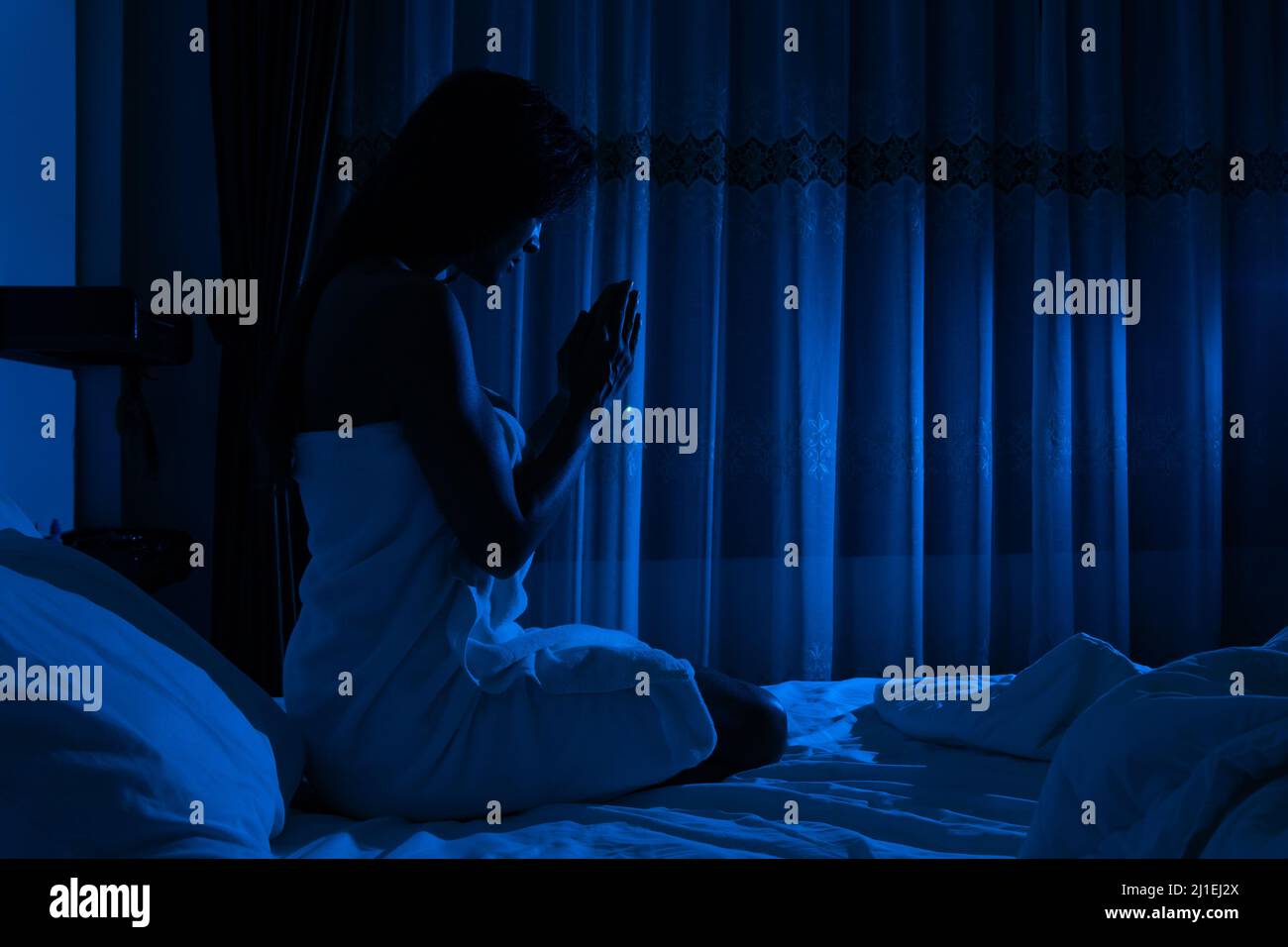 Ragazza che prega prima di andare a dormire Foto Stock
