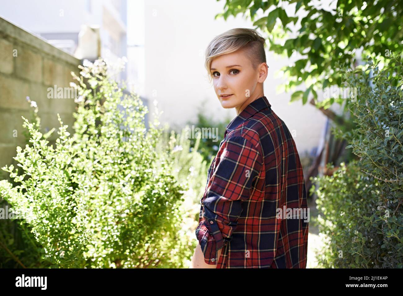 Lasciate che vi mostri il mio giardino vegetariano.... Un ritratto corto di una bella giovane donna in piedi nel suo giardino. Foto Stock