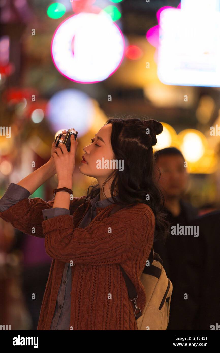 Giovani studentesse universitarie di sesso femminile stanno fotografando ad un mercato notturno a Pechino - foto di scorta Foto Stock
