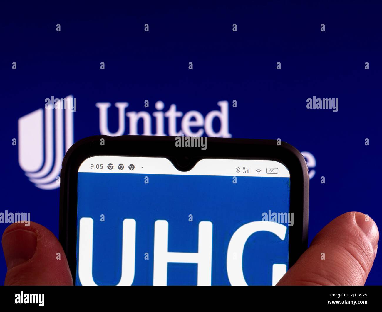 In questa foto, il logo UnitedHealthcare Inc viene visualizzato sullo schermo dello smartphone e sullo sfondo. Foto Stock