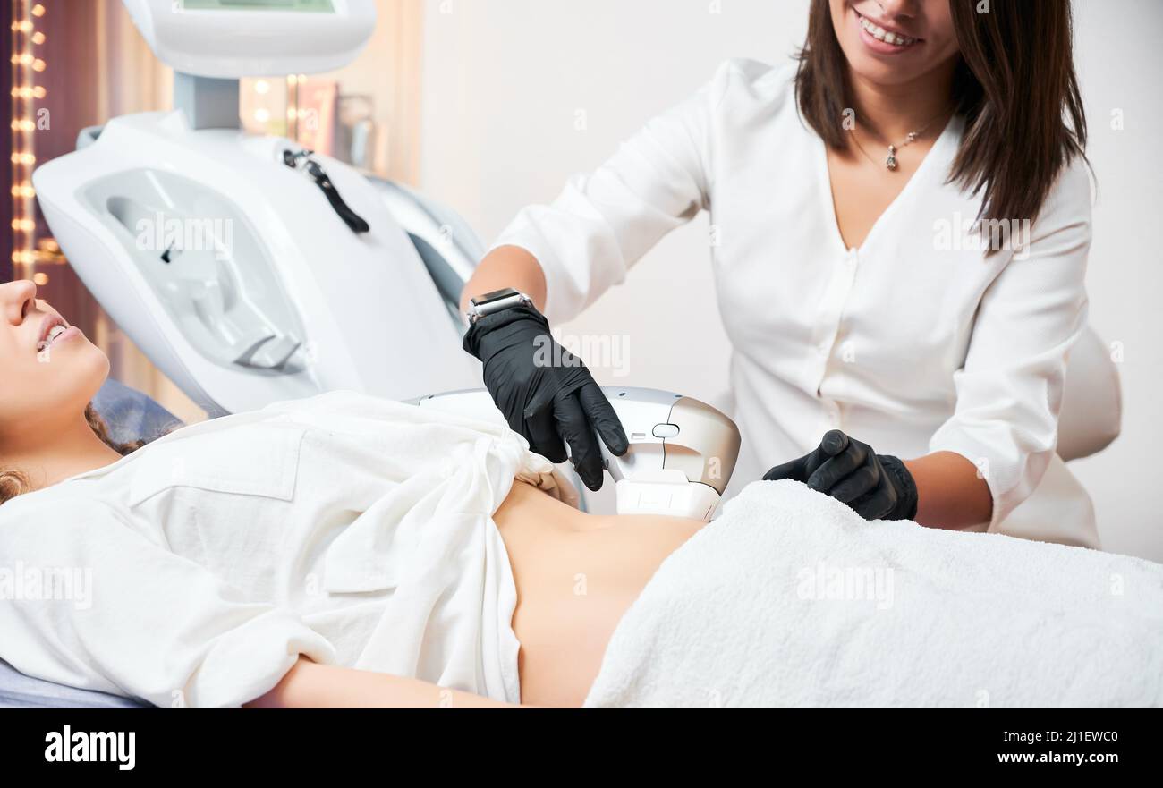 Medico donna che fa ecografia addome scansione per il paziente in guanti di gomma nera. Concetto di attrezzature moderne in clinica per migliorare la salute. Foto Stock