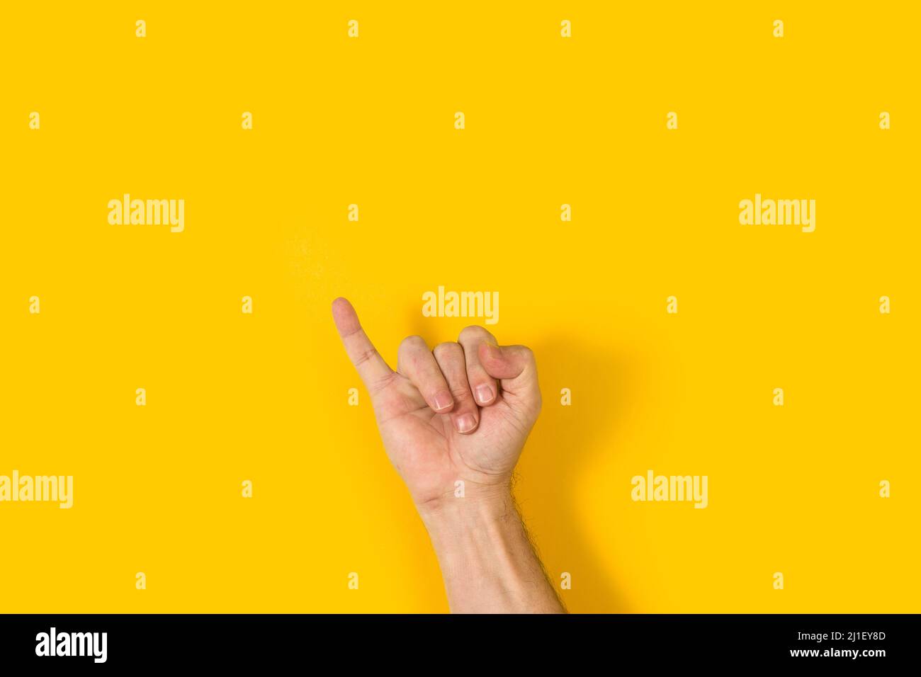 Mano dell'uomo con il dito piccolo si alza su uno sfondo giallo Foto Stock