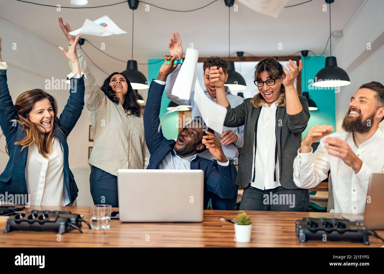 Il team aziendale di persone diverse celebra il successo del lavoro in ufficio Foto Stock