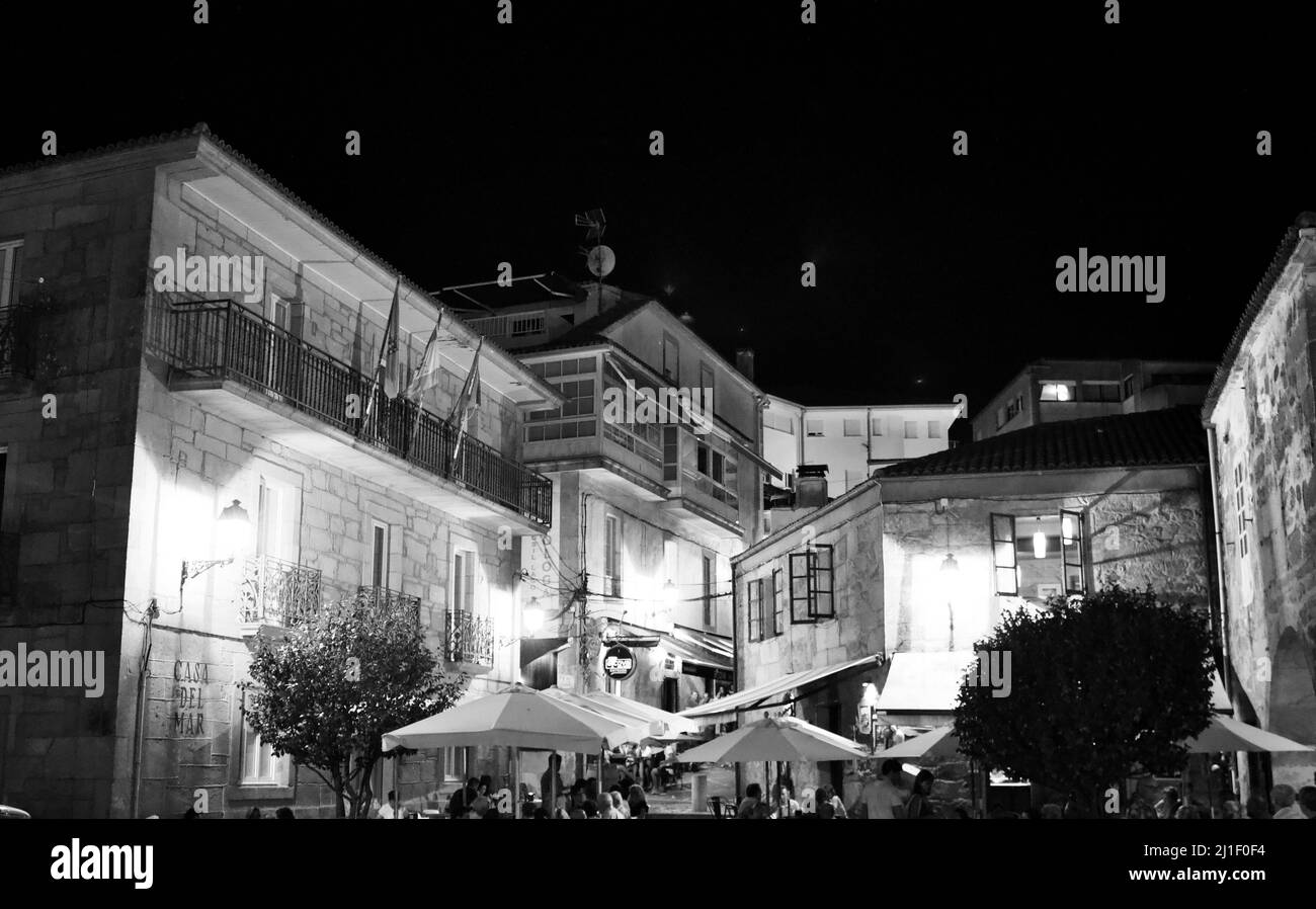 Una piazza in muros con tavoli e persone che mangiano e bevono di notte Foto Stock