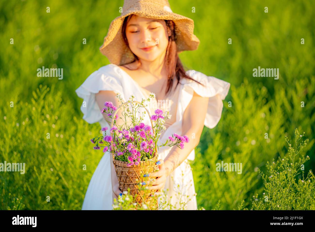 Donna felice a braccia aperte respirando intorno. Freedom Girl jumping e godere della vita contro il cielo blu nel giardino dei fiori. Foto Stock