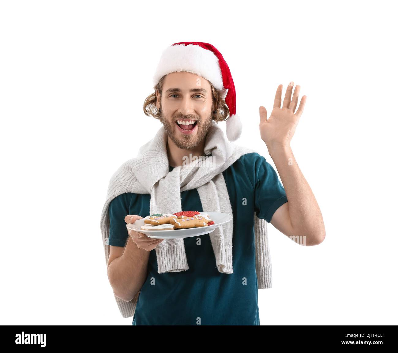 Giovane uomo in Santa cappello piatto con biscotti di pan di zenzero su  sfondo bianco Foto stock - Alamy
