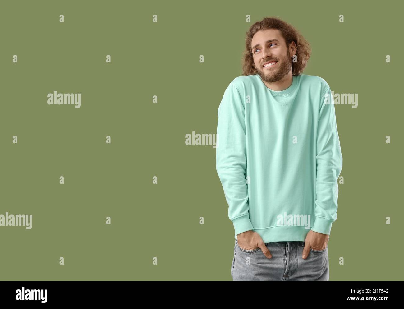 Giovane uomo sorridente in felpa su sfondo verde Foto Stock