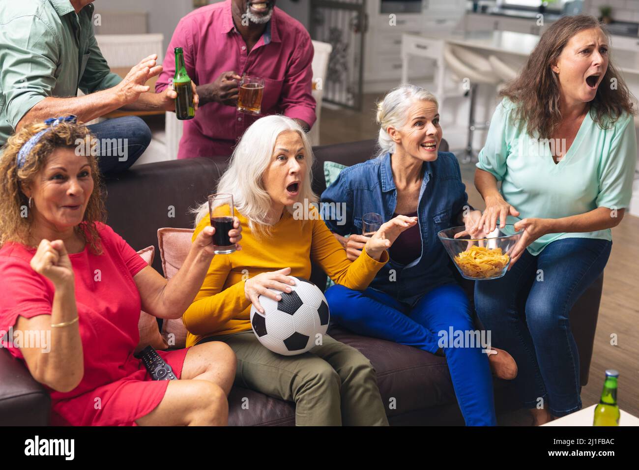 Scioccato multirazziale senior maschile e femminile amici che guardano la partita di calcio in tv a casa Foto Stock