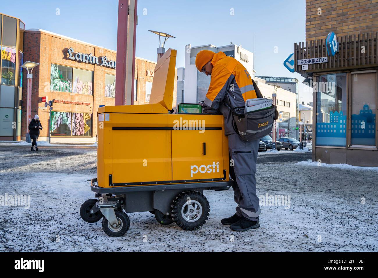 Rovaniemi, Finlandia - 16th marzo 2022: Un postino finlandese con carrello motorizzato, in una giornata invernale in una strada Rovaniemi, Finlandia. Foto Stock