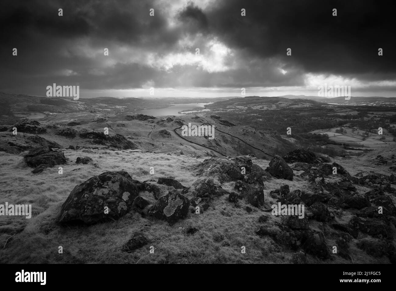 Un'immagine in bianco e nero di Loughrigg cadde con il lago Windermere oltre nel Lake District National Park, Cumbria, Inghilterra. Foto Stock