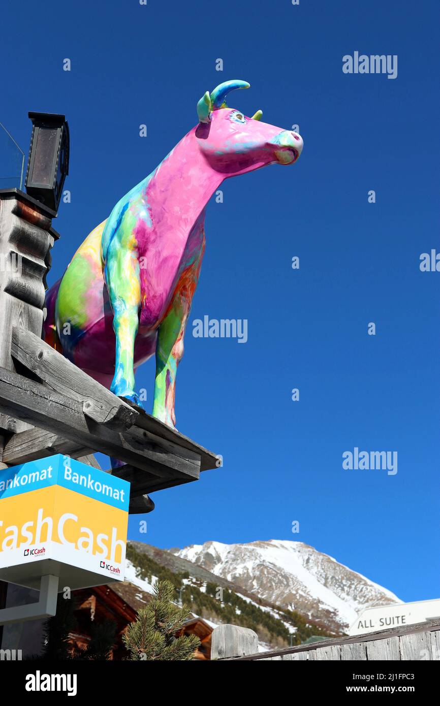 Modello di vacca multicolore contro un cielo blu brillante: Il logo del ristorante Kuhtaier Dorfstadl nello sci della località di Kuhtai, Alpi tirolesi, Austria Foto Stock
