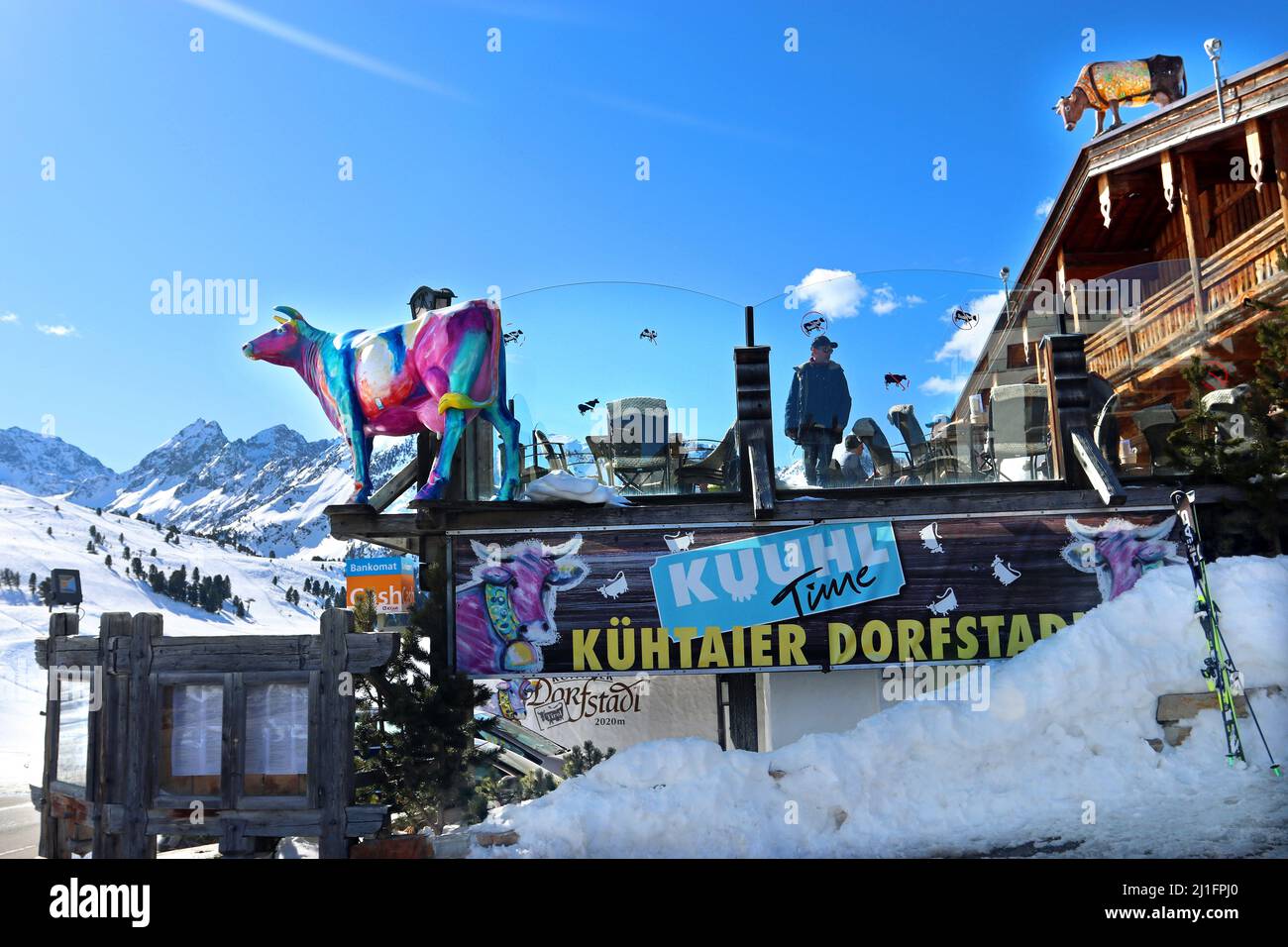 Modello di vacca multicolore contro un cielo blu brillante: Il logo del ristorante Kuhtaier Dorfstadl nello sci della località di Kuhtai, Alpi tirolesi, Austria Foto Stock