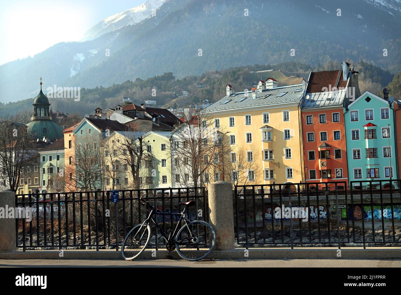 Uno dei siti più iconici di Innsbruck, la fila colorata di edifici dell'architettura Inn-Salzach sul fiume Inn; montagna Nordkette alle spalle Foto Stock