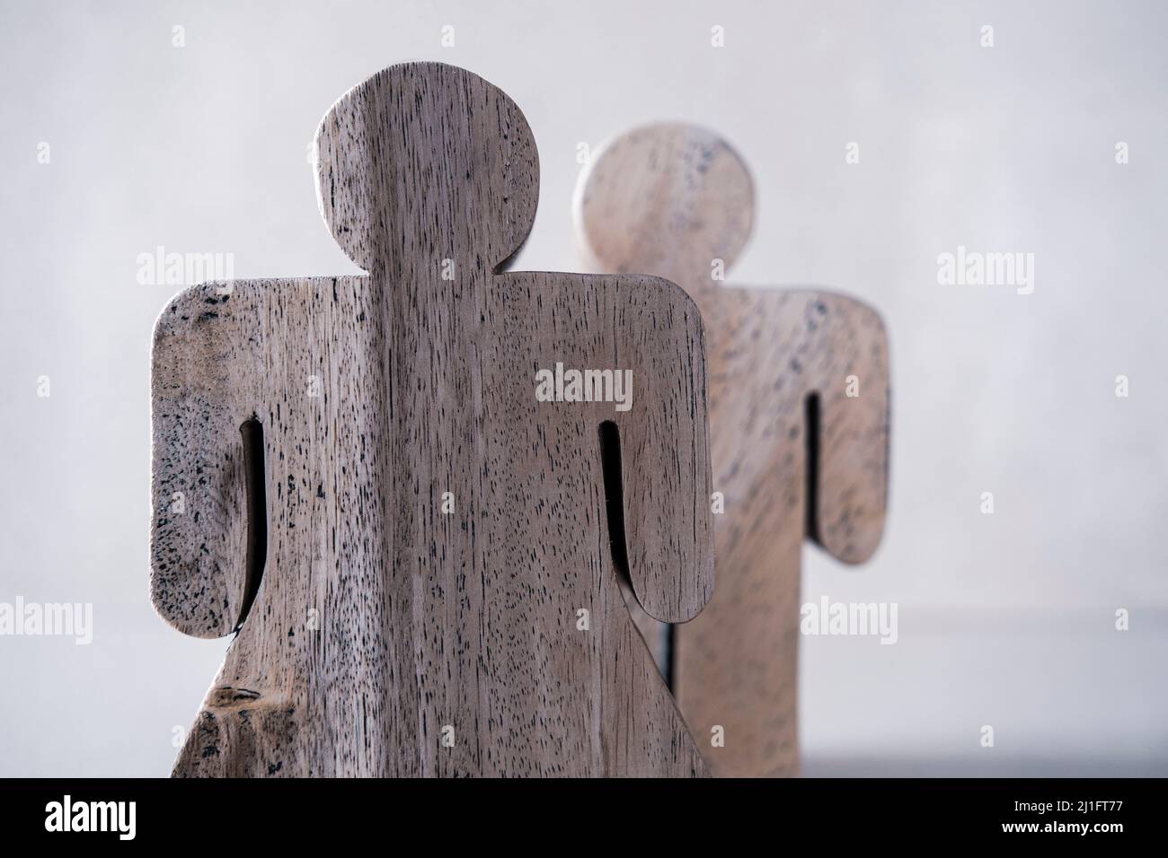 figure di uomo e donna in legno su sfondo neutro Foto Stock