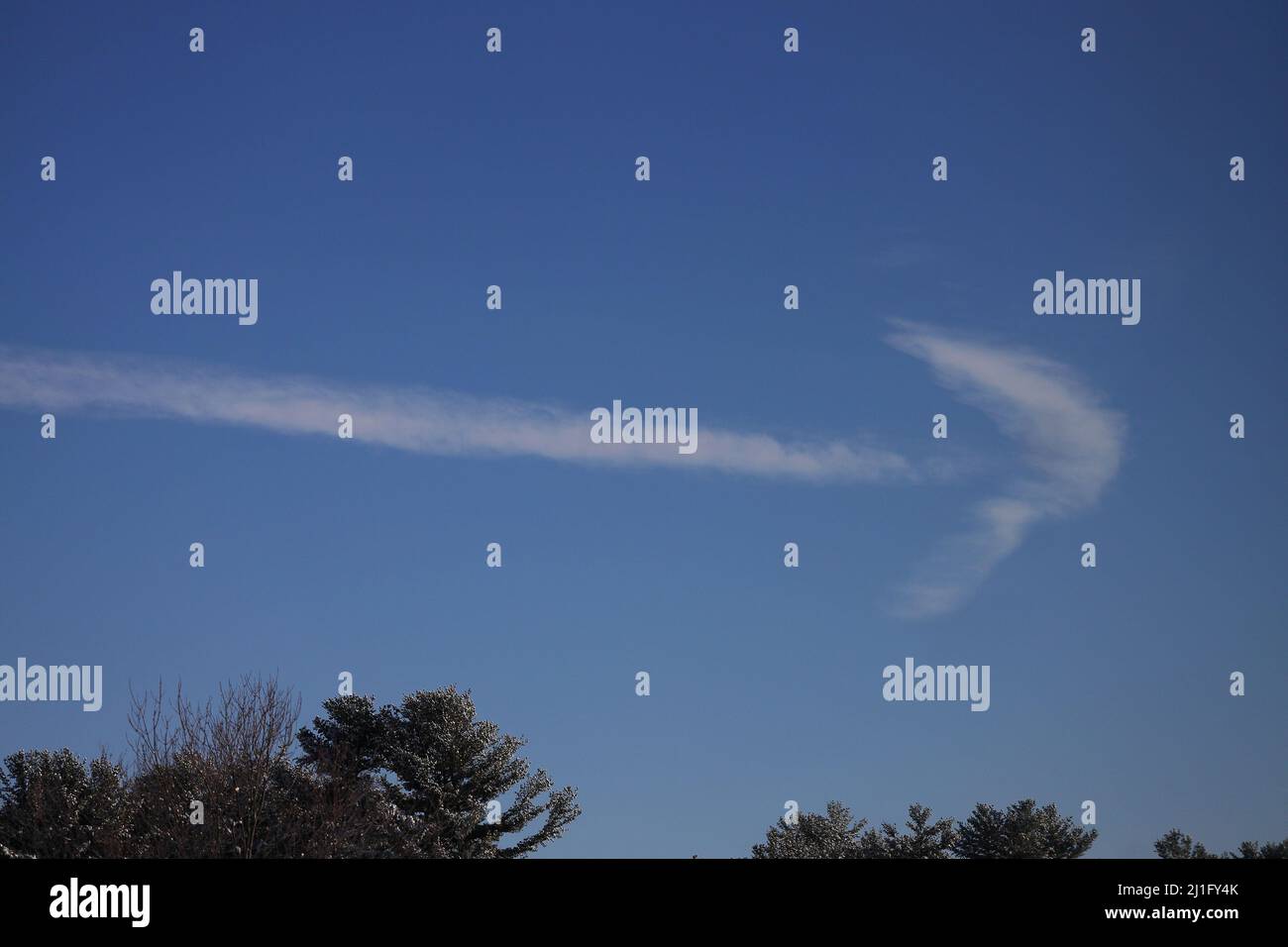 Nuvole in una giornata di cielo blu che assomiglia a una freccia destra Foto Stock