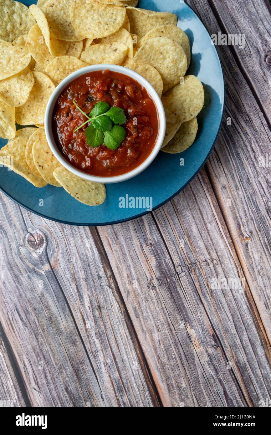 Tortilla patatine e salsa su un vassoio blu Foto Stock