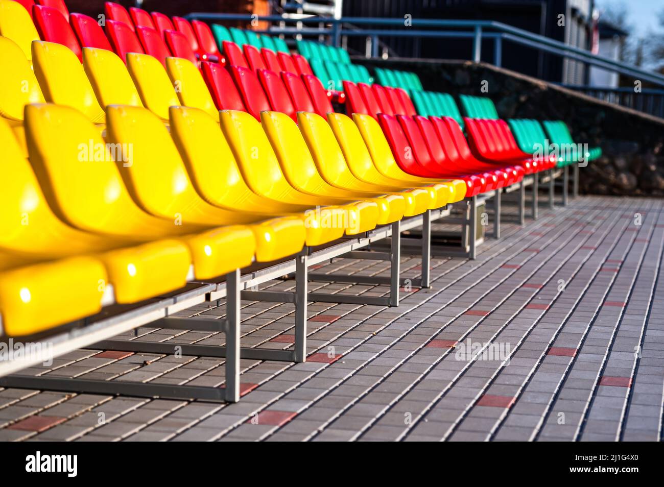 un frammento della tribuna di uno stadio sportivo con sedili multicolore Foto Stock