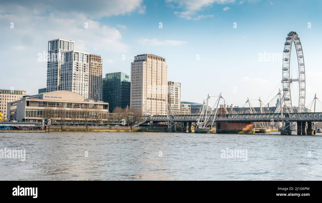 La South Bank, Londra. Una vista a sud sul Tamigi verso l'Hungerford Bridge, il Royal Festival Hall e i punti di riferimento del London Eye. Foto Stock