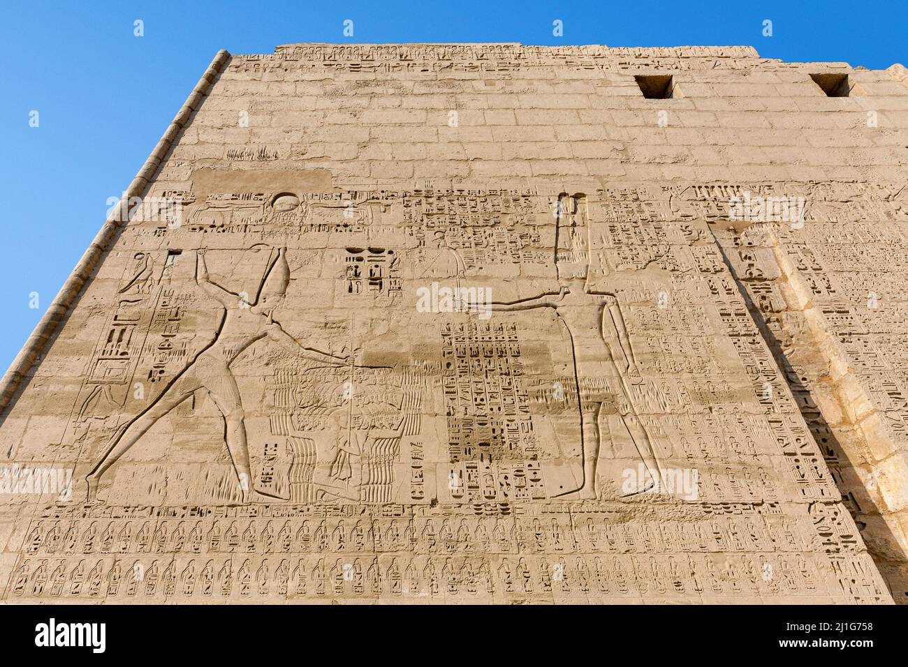 Il massacro rituale dei prigionieri asiatici di Ramesse III offerto al dio Amun-Ra, torre sud del primo pilone del Tempio mortuario, Medinet Habu Foto Stock