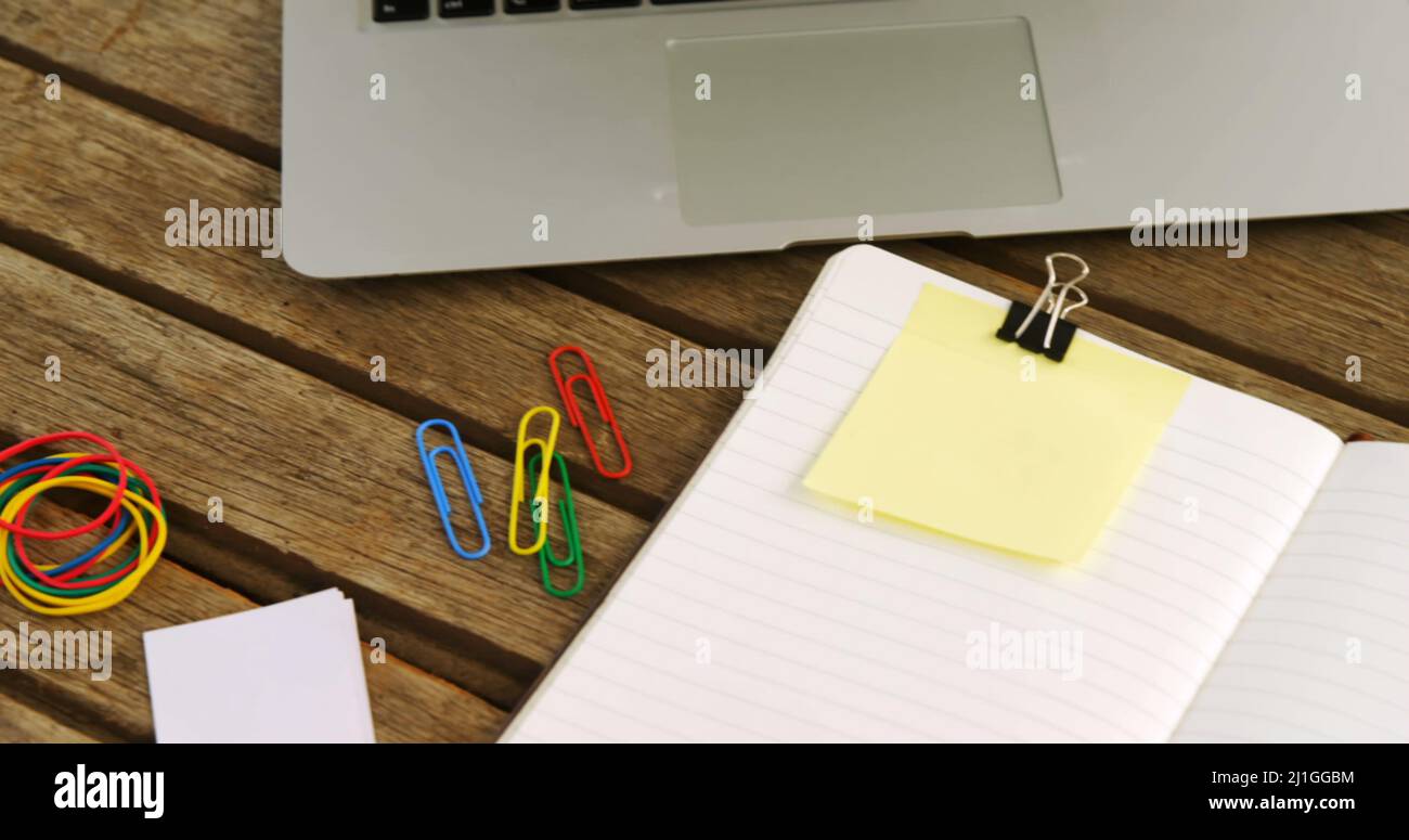 Immagine del testo "Keep your desk clean" sulla nota gialla della memoria sulla scrivania con computer portatile, caffè e notebook Foto Stock