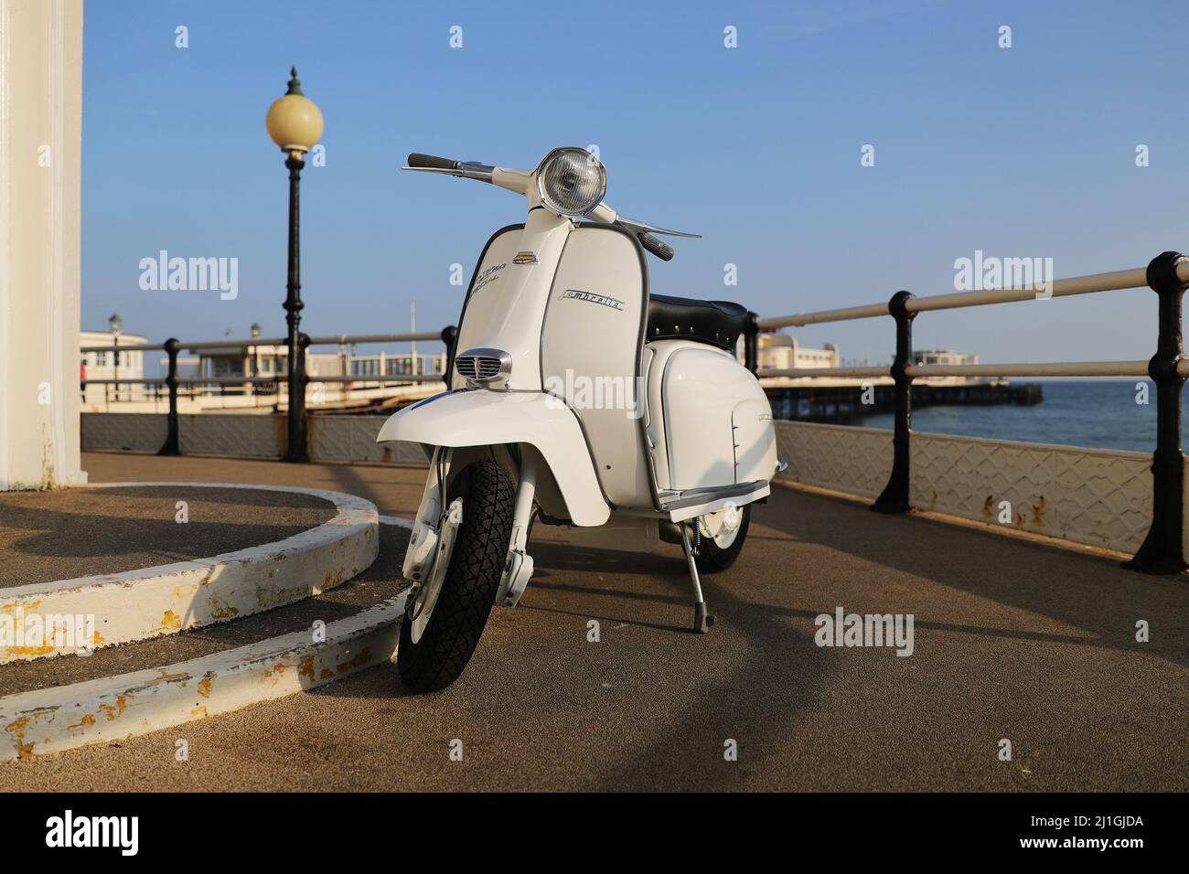 Italiano Innocenti Lambretta SX150 scooter a motore, fotografato sul lungomare di Worthing, il molo, il Duomo, barca da pesca Foto Stock