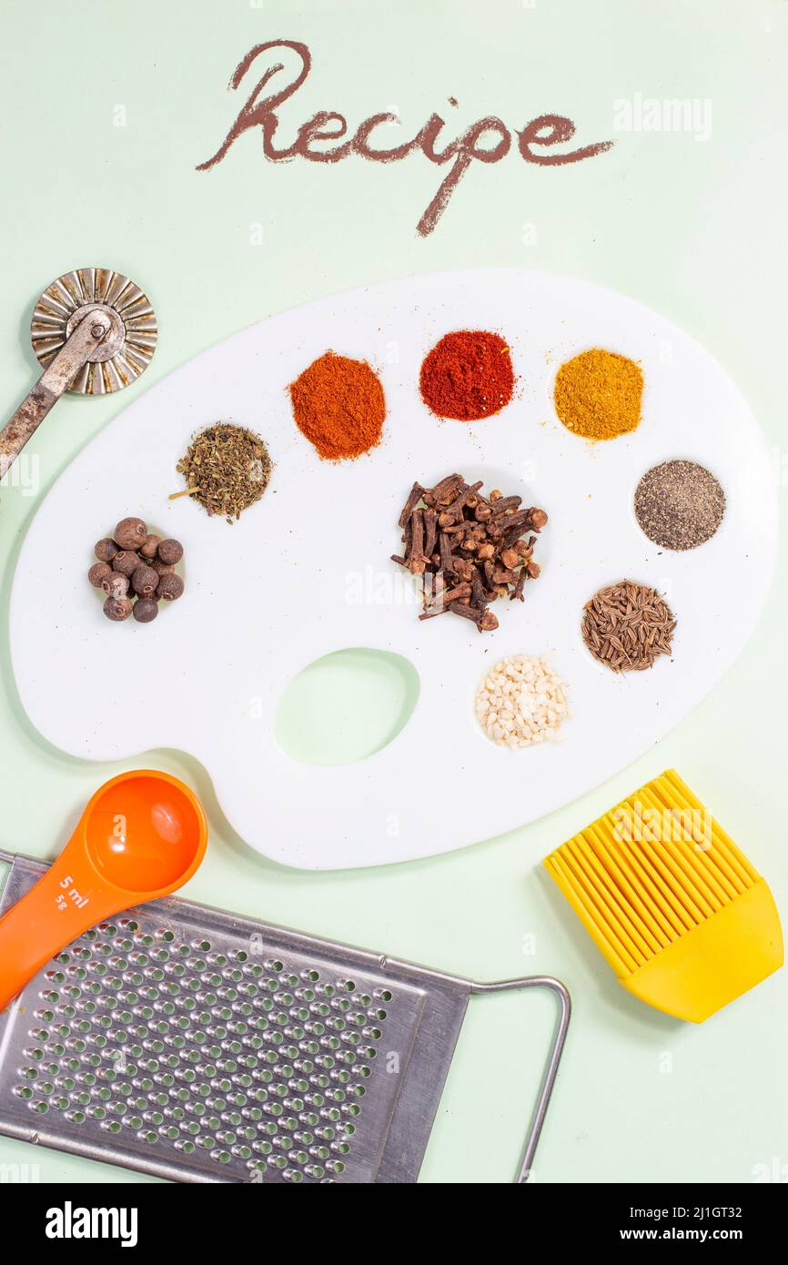 ricetta scritta accanto alla tavolozza di un pittore piena di condimenti e spezie Foto Stock