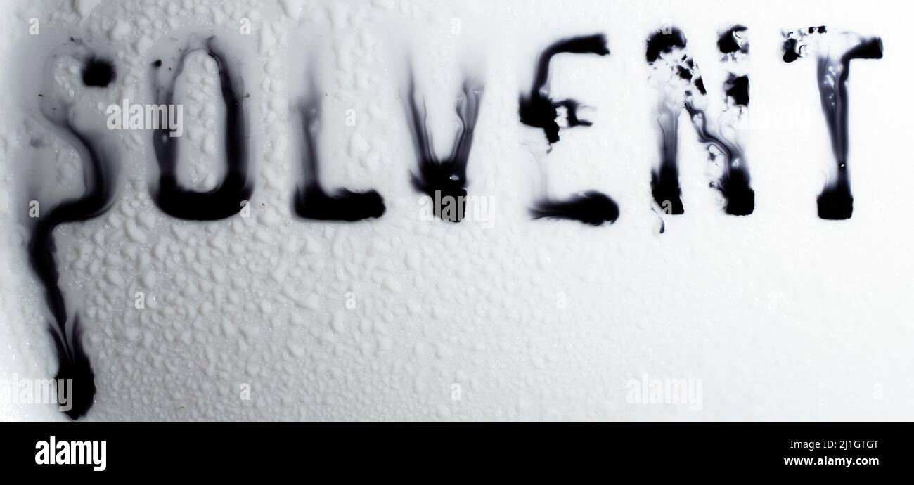solvente scritto su ceramica bianca, spruzzato e sciogliente Foto Stock