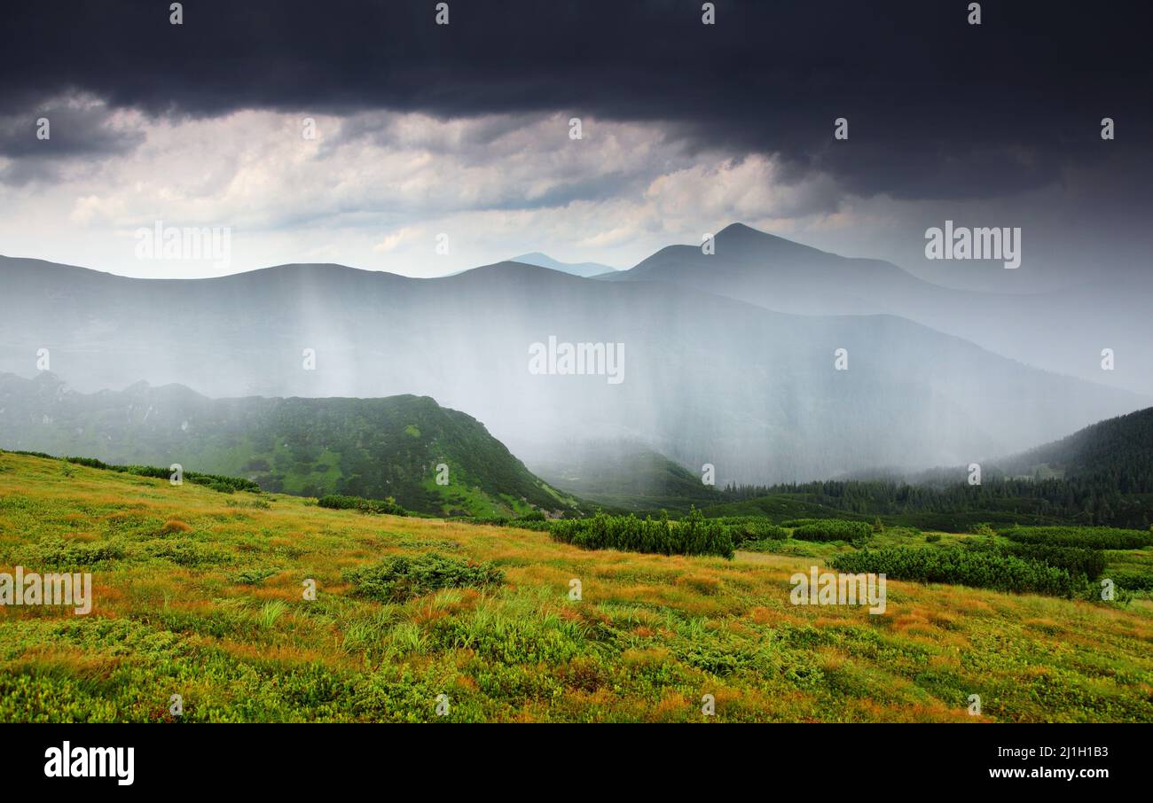 Splendida vista sulle nuvole di pioggia sulle montagne boscose. Scena drammatica e pittoresca. Dove si trova Parco Nazionale Chornogora, Carpazi, Ukra Foto Stock