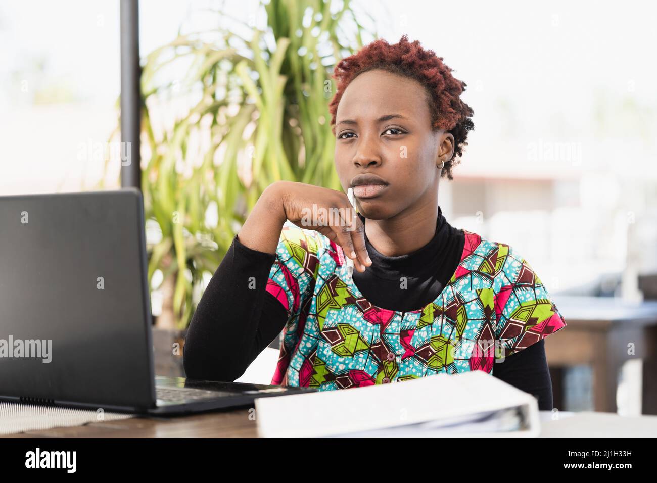 Primo piano della giovane donna africana della carriera che cerca l'ispirazione mentre lavora al suo concetto di emancipazione del taccuino.della ragazza. Foto Stock