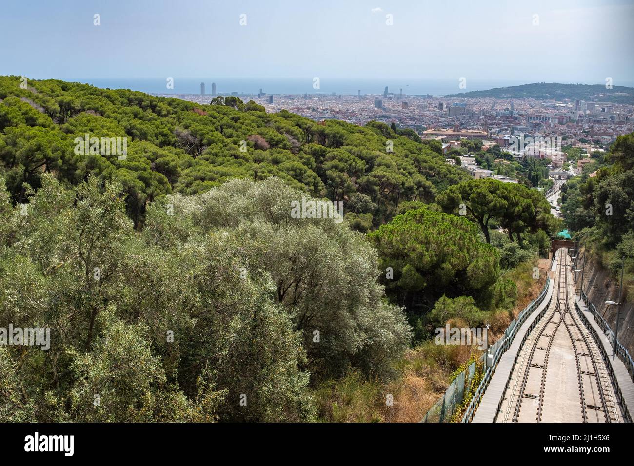 La ferrovia funicolare tra i boschi del Monte Tibidabo a Barcellona, in Spagna. Paesaggio urbano durante il giorno. Foto Stock