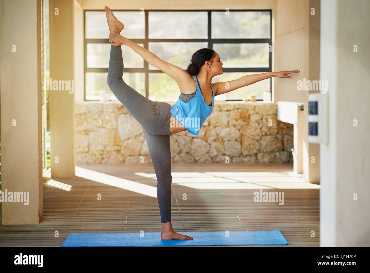 Verso uno stile di vita sano. Shot di una giovane donna che pratica lo yoga a casa. Foto Stock