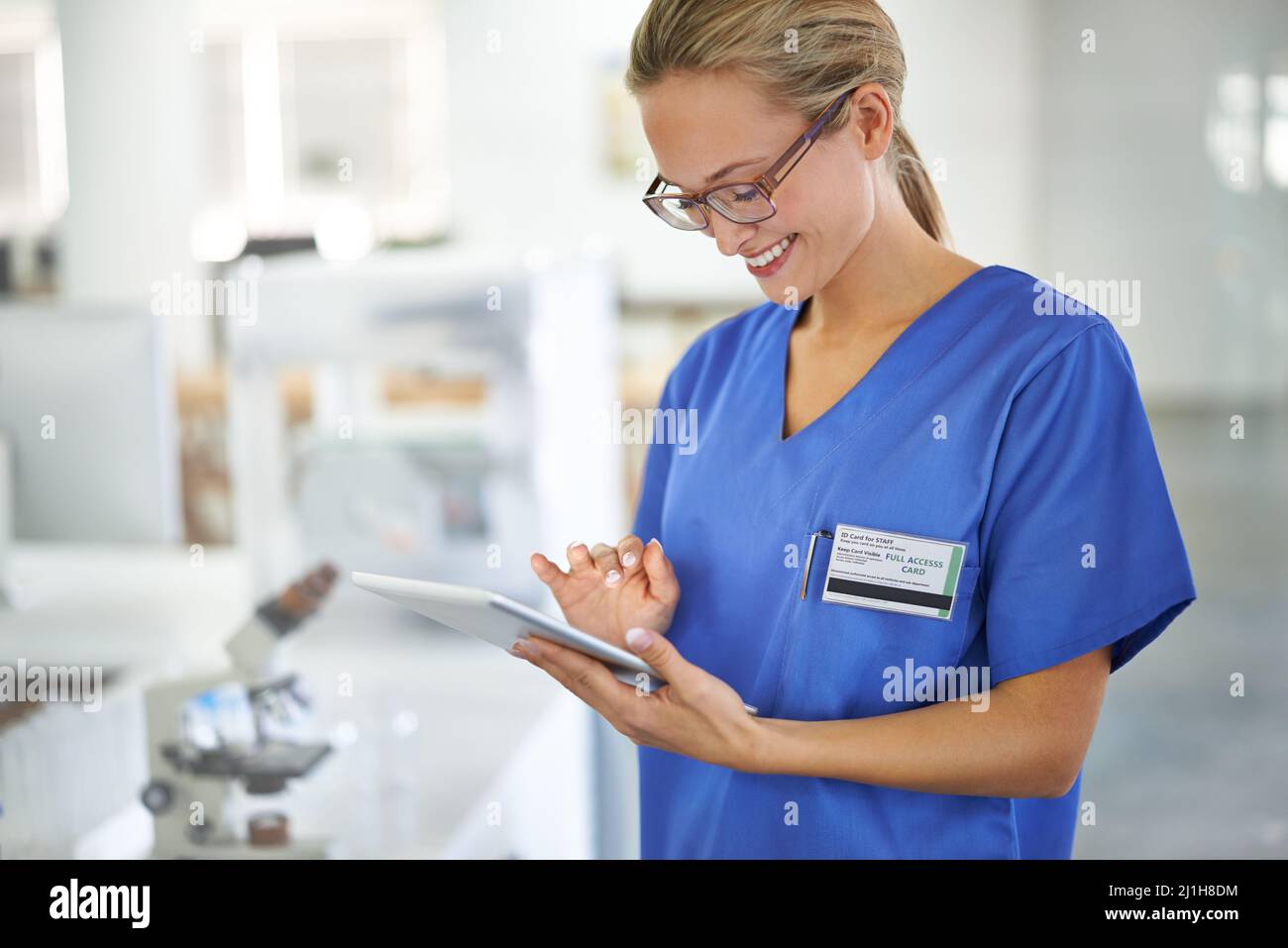 Supporto per un chirurgo. Una bella dottoressa che tiene una compressa mentre si trova in un laboratorio. Foto Stock