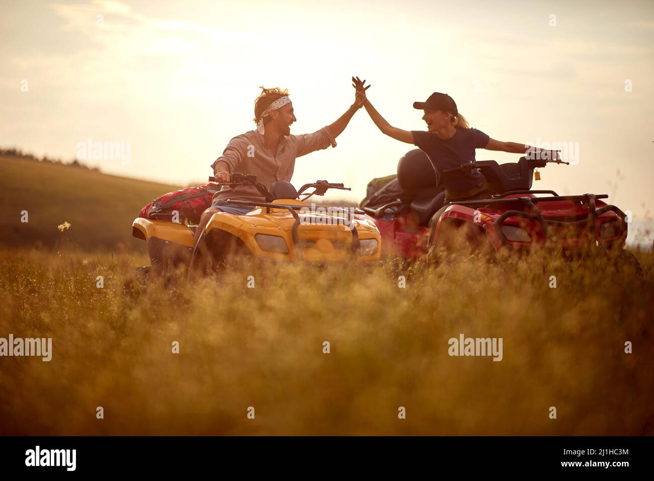 Il giovane e la ragazza sorridente godono di guidare il quad nella natura. Foto Stock
