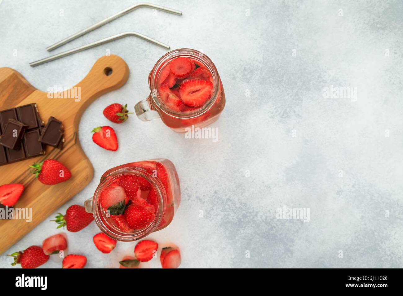 Bevanda alla fragola con frutti di bosco e tavola di legno con cioccolato fondente. Foto Stock
