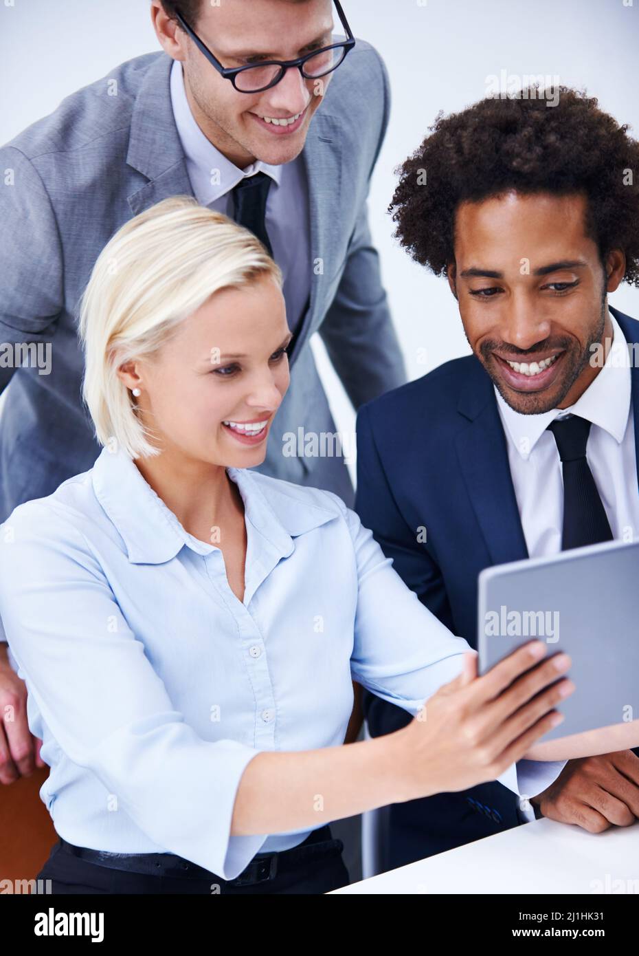 Conoscere il software più recente. Scatto di gruppo di tre colleghi che tengono un tablet digitale. Foto Stock