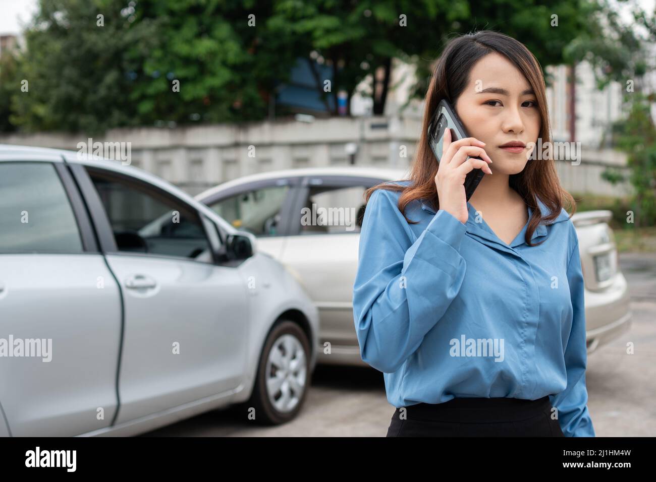 Donna driver chiamare assicurazione dopo un incidente auto prima di scattare foto e inviare assicurazione. Idea di reclamo in linea di assicurazione di incidente dell'automobile dopo la presentazione Foto Stock