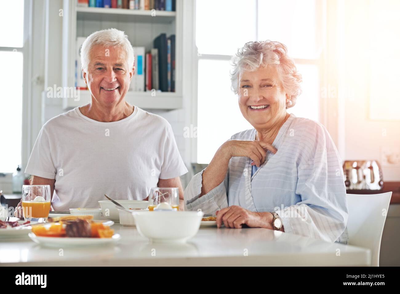 Non si tratta solo di condividere la colazione, ma anche di condividere l'amore. Ritratto di una coppia anziana che ha fatto colazione insieme a casa. Foto Stock