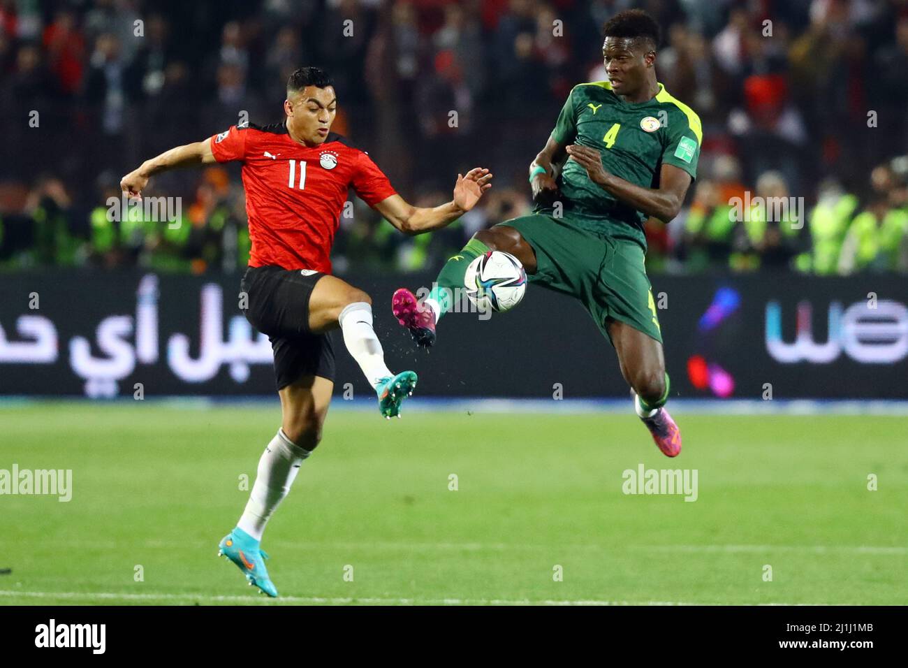 Cairo, Egitto. 25th Mar 2022. Mostafa Mohamed (L) d'Egitto vien con Pape Abou Cisse del Senegal durante la prima tappa della partita di calcio di qualificazione della Coppa del mondo 2022 tra Egitto e Senegal al Cairo, Egitto, il 25 marzo 2022. Credit: Nantong/Nantong/Nantong Live News Foto Stock