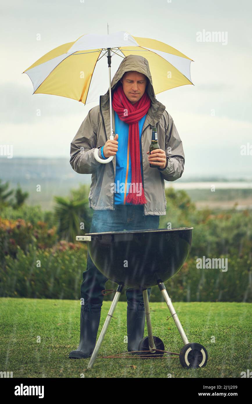 Veri uomini bbq in qualsiasi momento. Colpo di un uomo che abbaia sotto la pioggia. Foto Stock