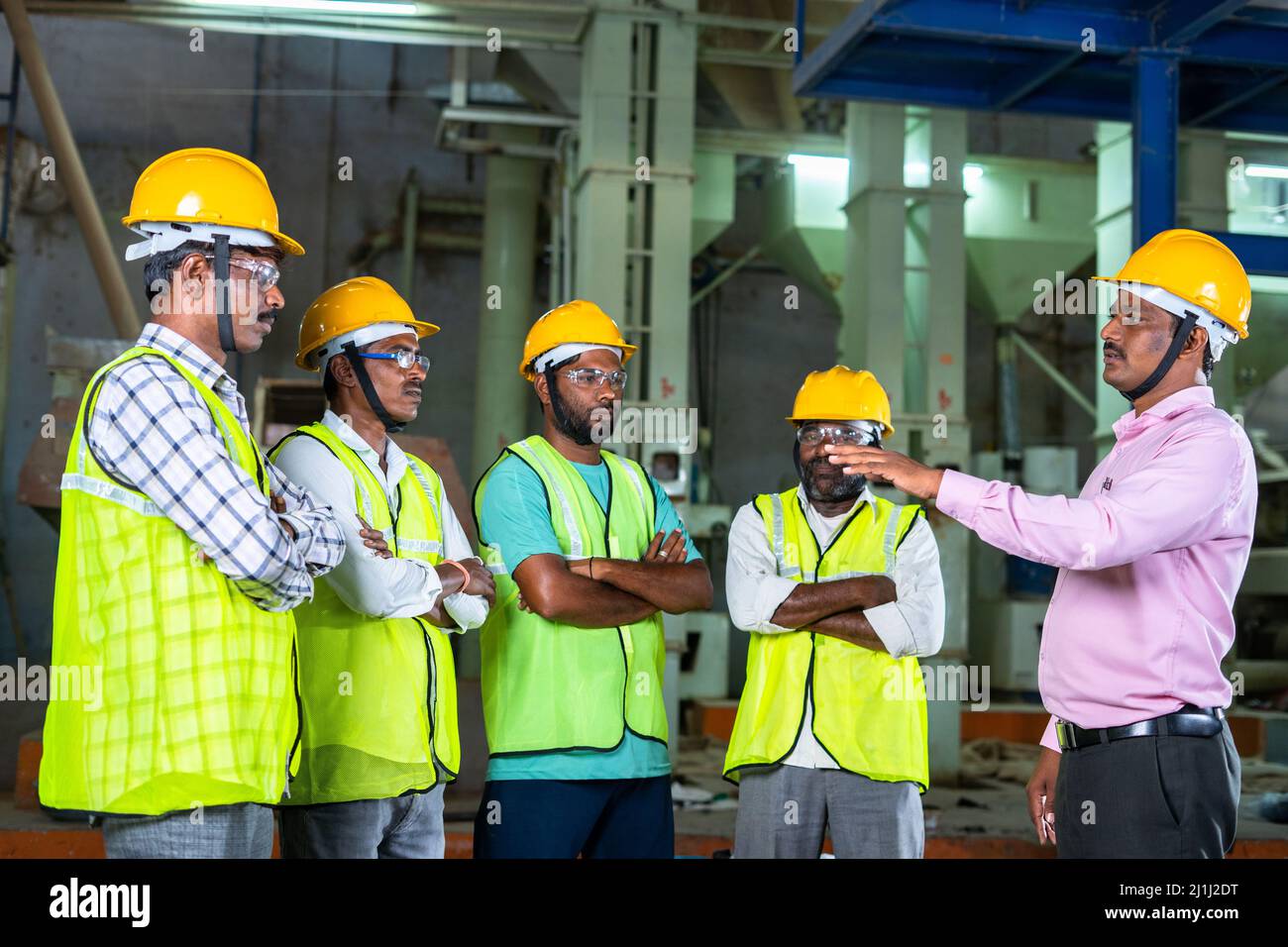 responsabile o supervisore che consiglia o assegna il lavoro ai lavoratori in fabbrica - cricnept di lavoro di squadra, leadership e capacità di comunicazione al palco del lavoro Foto Stock