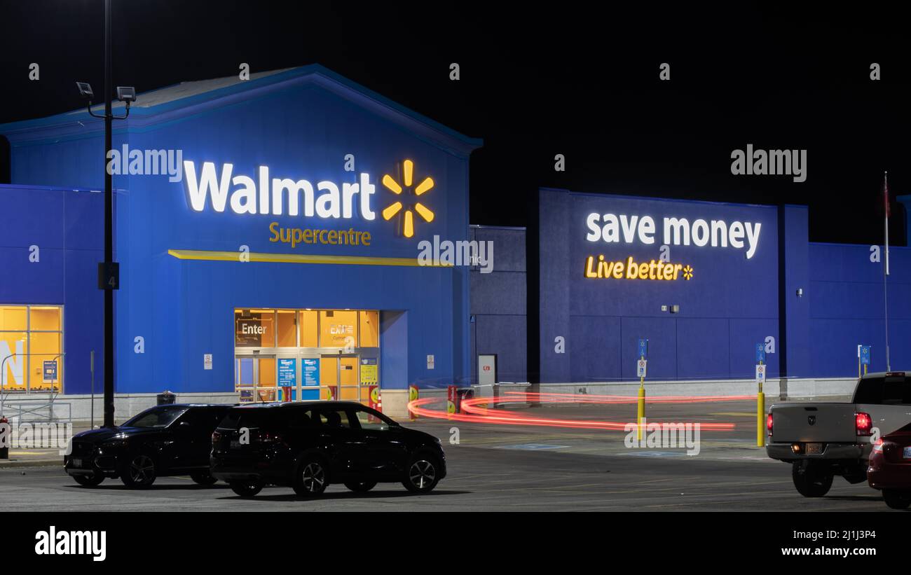 La parte anteriore di un Walmart Superstore è raffigurata a tarda notte mentre una macchina passa accanto. Foto Stock