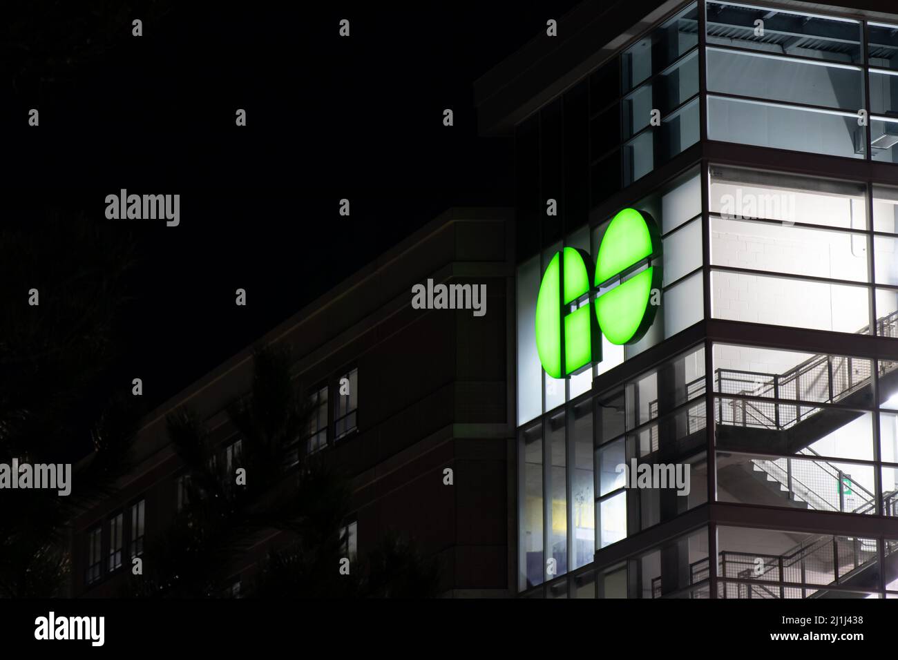 Il logo GO Transit, un sistema di trasporto pubblico regionale che serve l'area di Toronto, risplende di verde su un edificio della stazione ferroviaria a Mississauga, Ontario. Foto Stock