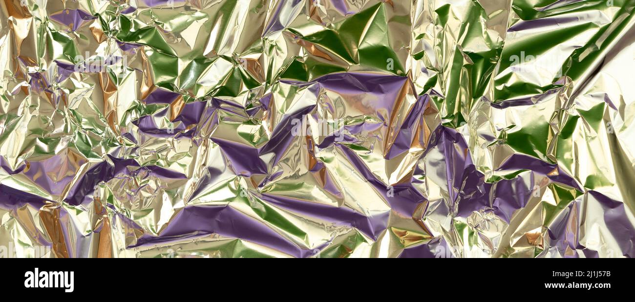 Astratto argento alluminio rugoso foglio multicolore fondo tessuto riflettente viola, verde chiaro. Lucentezza metallizzata in lamina argentata Foto Stock