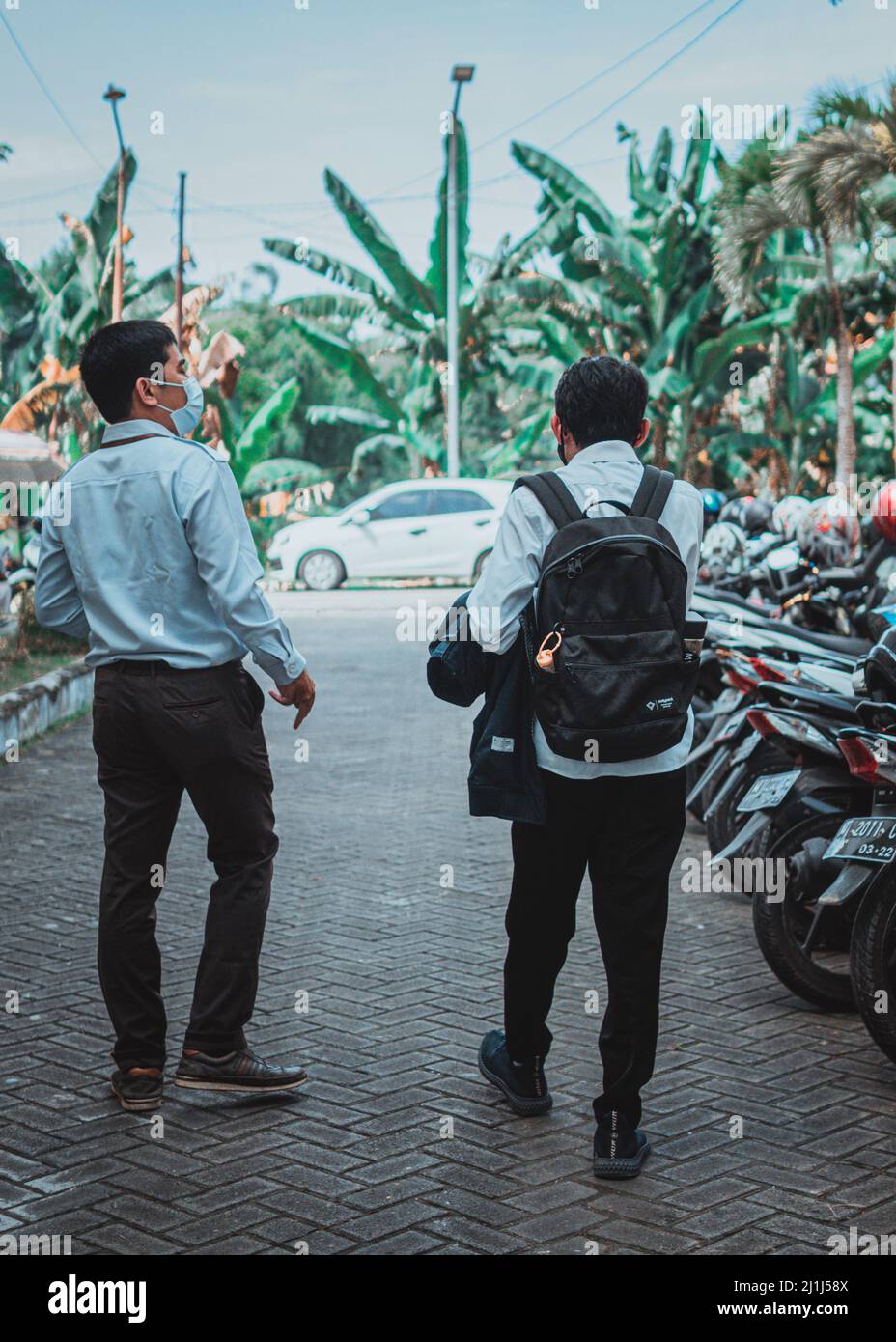 Due addetti alle vendite dell'azienda stanno offrendo merci da un'azienda nell'area di Sampang Foto Stock